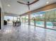 Expansive screened patio with sleek tile flooring, ceiling fan, and outdoor dining area overlooking the pool at 18203 Pine Hammock Blvd, Lutz, FL 33548