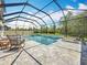 Beautiful screened-in pool with a spa, stone accents, sun shelves, and comfortable seating area for relaxation at 18203 Pine Hammock Blvd, Lutz, FL 33548