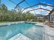 Gorgeous screened pool with spa, rock waterfall, and ample lounge seating for ultimate outdoor enjoyment at 18203 Pine Hammock Blvd, Lutz, FL 33548