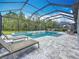 Inviting screened-in pool features a spa, sun shelves, stone accents, and plenty of space for lounging at 18203 Pine Hammock Blvd, Lutz, FL 33548