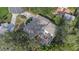 An expansive aerial view displays a home with patio furniture and a well-landscaped circular driveway at 1905 Pine Tree Ln, Belleair Bluffs, FL 33770