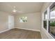Bright bedroom featuring neutral walls, wood-look flooring, a ceiling fan, and large windows at 1905 Pine Tree Ln, Belleair Bluffs, FL 33770