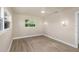 Neutral bedroom features light floors, fan, and unique wall sconces flanking the large window at 1905 Pine Tree Ln, Belleair Bluffs, FL 33770