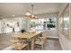 Bright dining room features a modern light fixture, wood table set and view into the kitchen at 1905 Pine Tree Ln, Belleair Bluffs, FL 33770