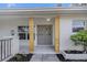 Stylish gray double front door with decorative glass panels and contemporary wood support beams at 1905 Pine Tree Ln, Belleair Bluffs, FL 33770