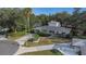 Beautiful home with a circular driveway, lush landscaping, and a mix of trees at 1905 Pine Tree Ln, Belleair Bluffs, FL 33770