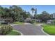 Well-maintained home with a circular driveway surrounded by mature trees and lush landscaping at 1905 Pine Tree Ln, Belleair Bluffs, FL 33770
