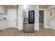Stainless steel refrigerator and white cabinets with gold hardware and woodgrain vinyl flooring at 1905 Pine Tree Ln, Belleair Bluffs, FL 33770