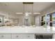 Kitchen island with modern countertops and fixtures; view to dining area and front entrance at 1905 Pine Tree Ln, Belleair Bluffs, FL 33770