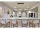 Modern kitchen features an island with seating, white cabinets, stainless appliances and modern lighting at 1905 Pine Tree Ln, Belleair Bluffs, FL 33770