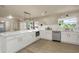 Kitchen featuring modern appliances, white cabinetry, stylish fixtures, and wood flooring at 1905 Pine Tree Ln, Belleair Bluffs, FL 33770