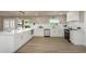 Bright kitchen with white cabinetry, stainless steel appliances, and wood flooring at 1905 Pine Tree Ln, Belleair Bluffs, FL 33770