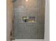 Clean modern shower featuring blue tile, niche, and rain-style shower head, creating a spa-like experience at 1905 Pine Tree Ln, Belleair Bluffs, FL 33770