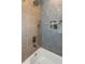 Clean bathroom shower featuring mixed style tiling, niche, and rain-style shower head, creating a spa-like experience at 1905 Pine Tree Ln, Belleair Bluffs, FL 33770