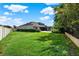 Expansive backyard with lush green grass, fenced perimeter, and a sparkling pool at 21028 Ski Way, Land O Lakes, FL 34638