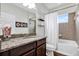 Well lit bathroom featuring granite countertop vanity, decorative elements, and tiled shower-tub at 21028 Ski Way, Land O Lakes, FL 34638