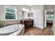 Bathroom featuring soaking tub, granite vanity, and tile accents, creating a spa-like retreat at 21028 Ski Way, Land O Lakes, FL 34638
