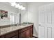 Bathroom featuring dark wood cabinetry, granite countertop, and modern lighting at 21028 Ski Way, Land O Lakes, FL 34638