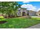Charming home with a well-manicured lawn and landscaped garden beds at 21028 Ski Way, Land O Lakes, FL 34638