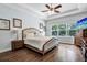 Serene main bedroom showcasing tray ceilings, hardwood floors, and a large window overlooking lush greenery at 21028 Ski Way, Land O Lakes, FL 34638