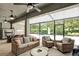 Covered patio with wicker furniture and ceiling fans overlooks the backyard pool at 21028 Ski Way, Land O Lakes, FL 34638