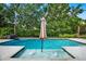 Inviting pool with built-in fountains and an umbrella offering shade on a sunny day at 21028 Ski Way, Land O Lakes, FL 34638
