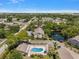 A high-angle shot showcases the pool and pond, surrounded by well-maintained residences and vibrant landscaping at 2170 Elm St # 906, Dunedin, FL 34698