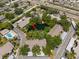 Aerial view of community with pond, mature trees, pool, and convenient parking at 2170 Elm St # 906, Dunedin, FL 34698