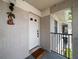 Private entrance to a unit with a welcome mat and a decorative light fixture at 2170 Elm St # 906, Dunedin, FL 34698