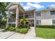 Inviting two-story condo featuring lush landscaping, an open walkway, and neutral color palette at 2170 Elm St # 906, Dunedin, FL 34698