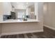 Open kitchen with white cabinets, stainless steel appliances, and a breakfast bar at 2170 Elm St # 906, Dunedin, FL 34698