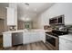 Bright kitchen features stainless appliances, white cabinetry, and modern backsplash at 2170 Elm St # 906, Dunedin, FL 34698