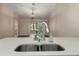 Modern kitchen sink featuring granite countertops and views of the living room at 2170 Elm St # 906, Dunedin, FL 34698