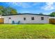 Well-maintained backyard with lush green grass, a charming white building, and a sturdy wooden fence at 219 80Th Ne Ave, St Petersburg, FL 33702
