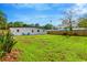Spacious backyard with lush green grass, a white house, and a well-maintained wooden fence at 219 80Th Ne Ave, St Petersburg, FL 33702