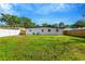 Lush backyard with green grass and a well-maintained fence, complemented by a charming white house at 219 80Th Ne Ave, St Petersburg, FL 33702