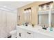 Modern bathroom with double vanity, white cabinetry, sleek fixtures, and stylish shower curtain at 219 80Th Ne Ave, St Petersburg, FL 33702
