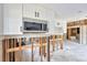 Kitchen with a stainless steel microwave and modern white cabinets waiting for renovation at 219 80Th Ne Ave, St Petersburg, FL 33702