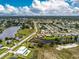Aerial view of the property in a waterfront community; the home has a screened pool at 2324 Hayworth Rd, Port Charlotte, FL 33952