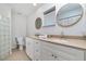 Bathroom with double vanity, framed mirrors, and a glass block shower at 2324 Hayworth Rd, Port Charlotte, FL 33952