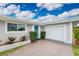 A well-maintained single-story home featuring a blue front door, an attached garage, and fresh landscaping at 2324 Hayworth Rd, Port Charlotte, FL 33952