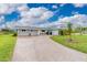 Charming single-story home with a well-maintained lawn and a long driveway leading to an attached garage at 2324 Hayworth Rd, Port Charlotte, FL 33952