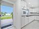 Bright white kitchen with modern appliances and tile flooring with a view of the outdoors at 2324 Hayworth Rd, Port Charlotte, FL 33952