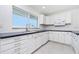 This stylish kitchen is equipped with sleek white cabinets, modern appliances, and tiled floors at 2324 Hayworth Rd, Port Charlotte, FL 33952
