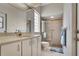 Bathroom featuring a vanity, toilet, glass block window and a shower with glass doors at 23420 Peachland Blvd, Port Charlotte, FL 33954