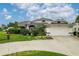 Home's exterior with a well-manicured lawn, mature landscaping, and a spacious driveway at 23420 Peachland Blvd, Port Charlotte, FL 33954