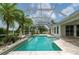 A beautiful screened-in pool with palm trees and lion statues at 23420 Peachland Blvd, Port Charlotte, FL 33954