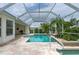 A beautiful screened-in pool with palm trees and lion statues at 23420 Peachland Blvd, Port Charlotte, FL 33954