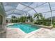 Inviting screened-in pool with travertine deck, lush landscaping, and ample space for entertaining at 23420 Peachland Blvd, Port Charlotte, FL 33954