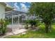 View of a screened-in pool area with stone decking and mature landscaping at 23420 Peachland Blvd, Port Charlotte, FL 33954